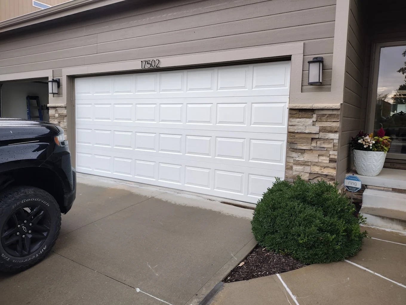 New white raised-panel garage door on home exterior